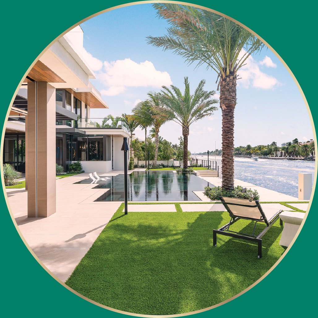 Waterfront luxury home with an infinity pool, palm trees and a manicured lawn