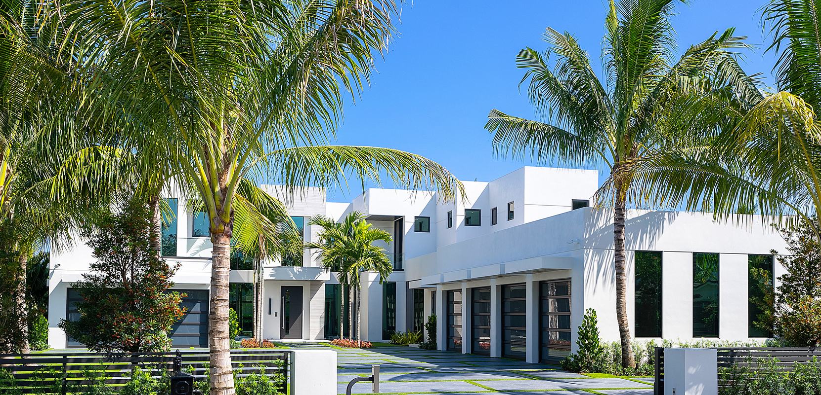 White modern homes framed by tall palms