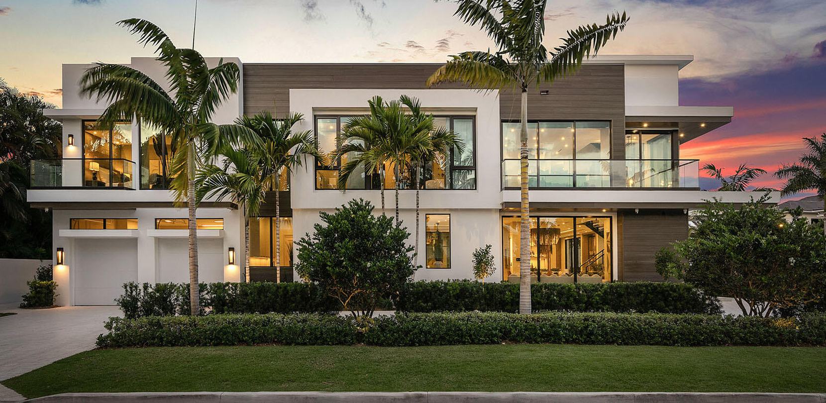 Modern home at sunset with palms and clipped hedges